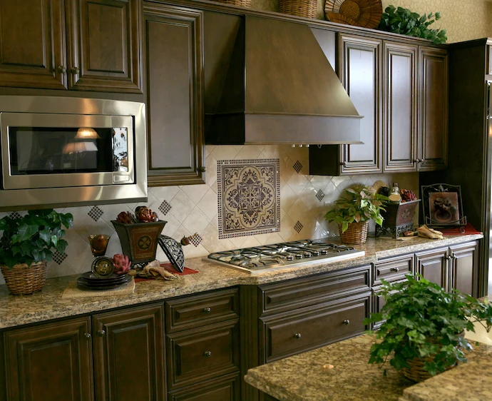 Luxury home kitchen with a gas range, ttle backsplash, and dark brown custom cabinets