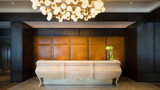 a reception desk in a hotel lobby with a chandelier