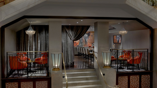 the lobby of a hotel with stairs and a chandelier