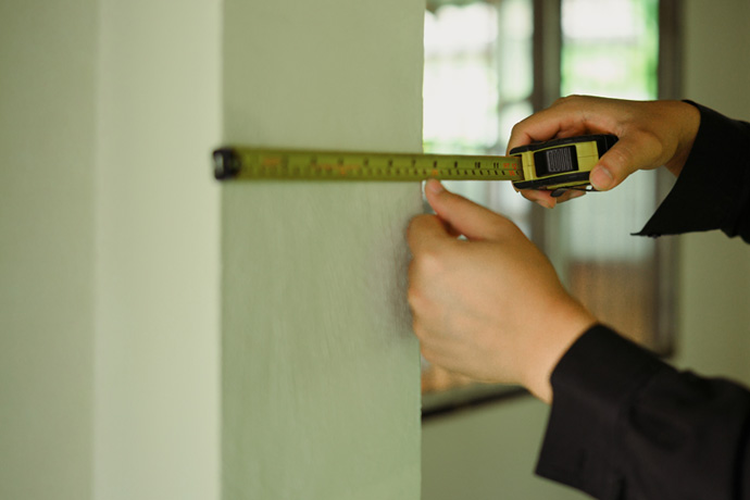 Worker measuring the wall