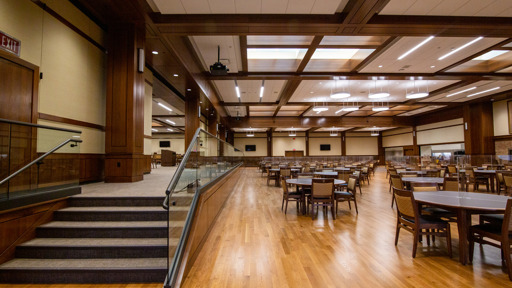 stairs in a large dining room with tables and chairs