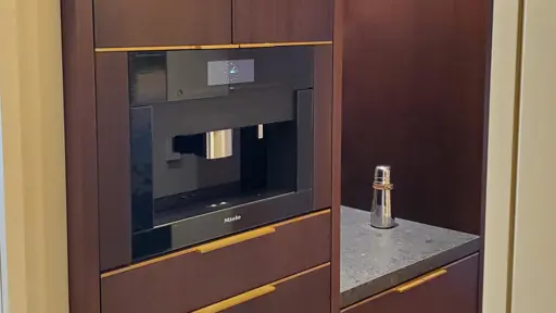 a coffee machine is in a cabinet in a kitchen