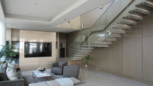 a living room with tv on the walls and stairs