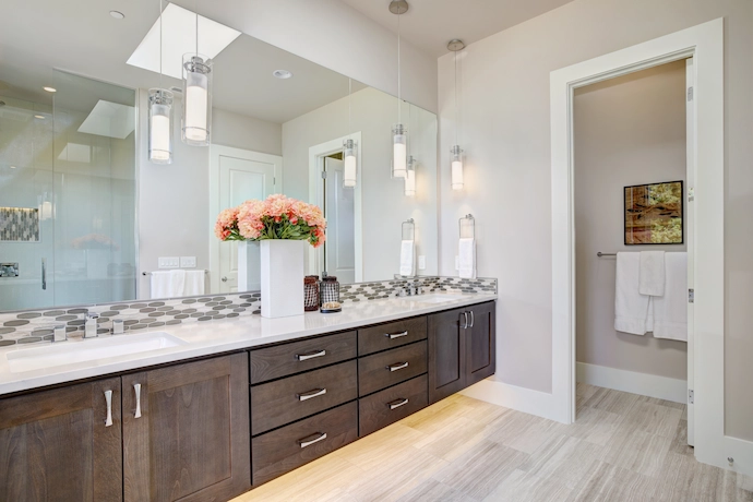 newly renovated bathroom vanity with white stone countertop and dark brown vanity cabinets