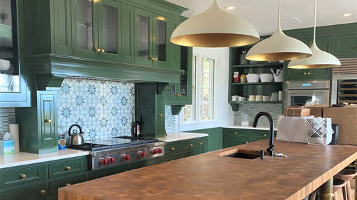 a kitchen with green cabinets and a wooden counter top