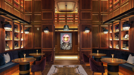the interior of a bar with bookshelves and a tiger on the wall
