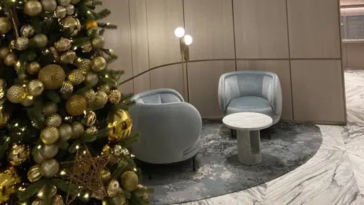 a christmas tree and chairs in a lobby