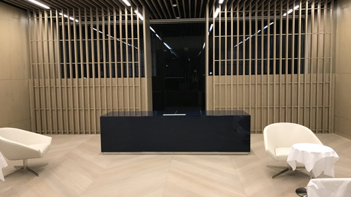 the lobby of a hotel with white chairs and a desk