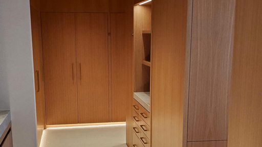 a hallway with wooden cabinets and a sink