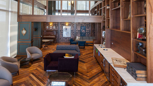 a living room with a wooden floor and wooden bookshelves