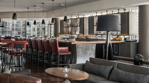 a bar with red bar stools and grey couch