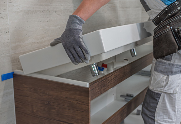 Worker installing sink